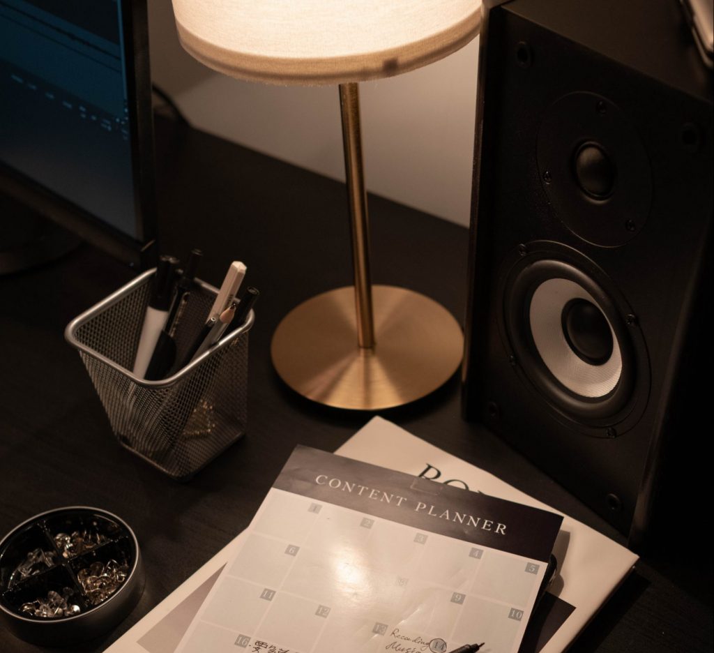Overhead photo of a content calendar with writing on it and a black speaker to the right