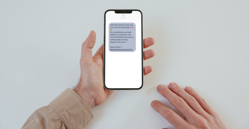 A person's hand with an SMS Marketing text