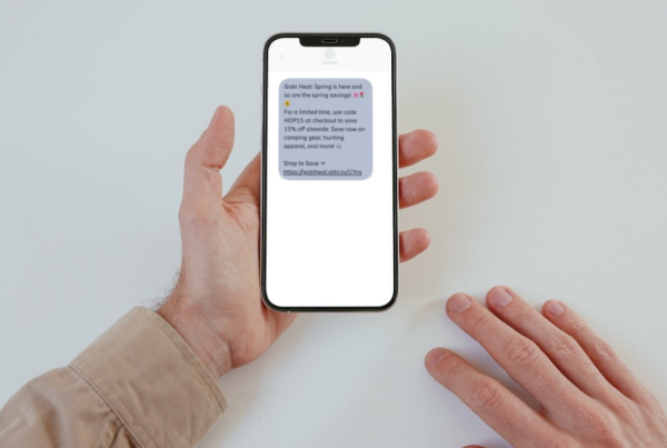 A person's hand with an SMS Marketing text