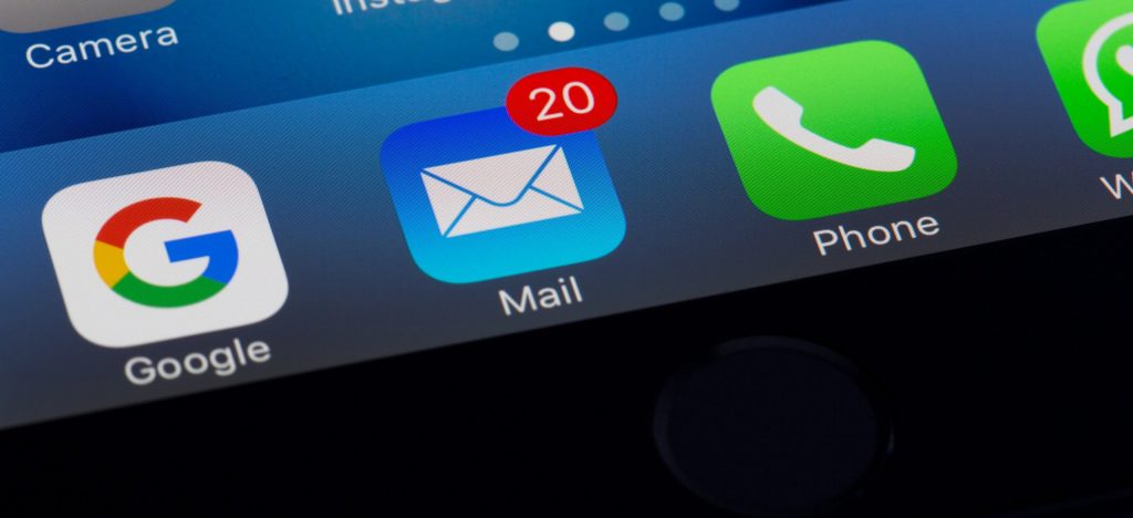 Bottom of a silver iPhone with the email button flagged with 20 emails