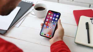 Man holding and looking at an iPhone home screen