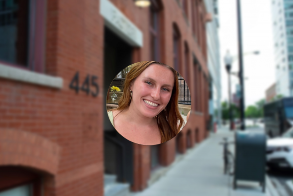 Circular photo of Kelsey Connolly with the background as the exterior of Logical's brick office building